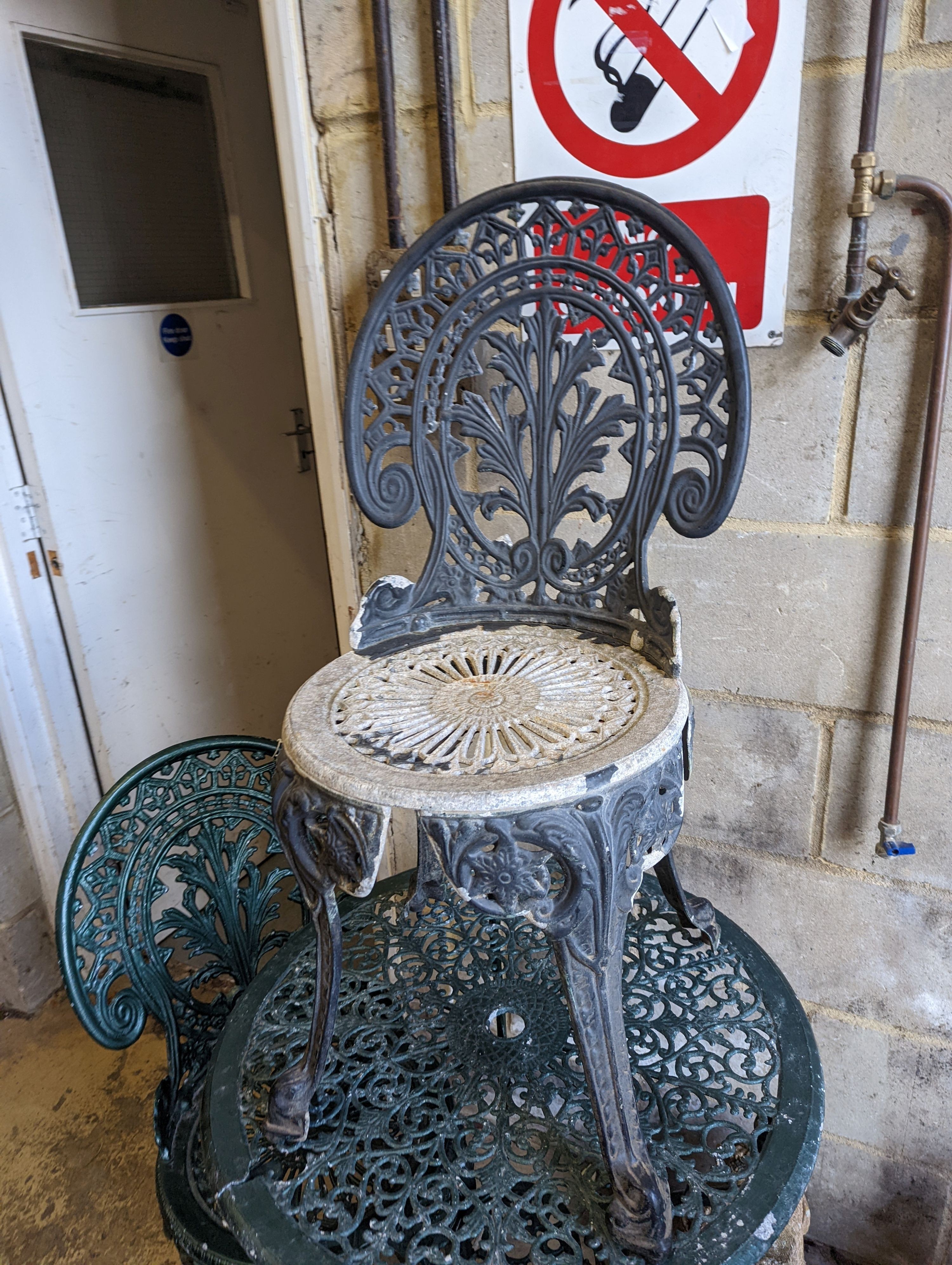 A circular painted aluminium garden table, diameter 65cm, together with three chairs